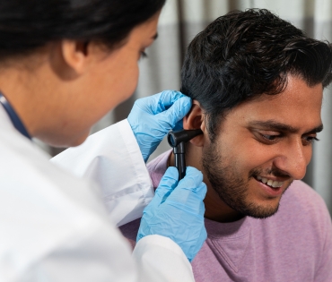 Doctor examining patient’s ear with otoscope at Medisure Hospital – best hospital in Kukatpally.