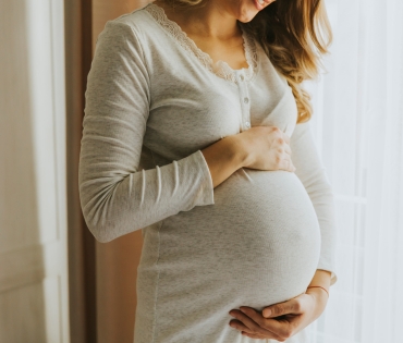 Pregnant woman gently holding baby bump at Medisure Hospital – best hospital in Kukatpally for maternity care.